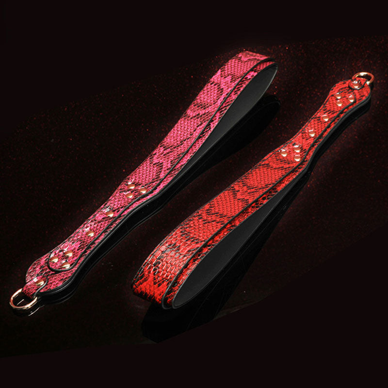Wondebliss snake print spanking paddle in red and fuchsia, flat lay display