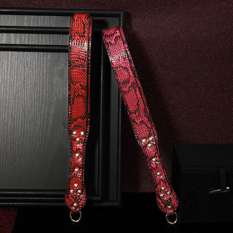 Wondebliss snake print spanking paddle in red and fuchsia, standing upright display