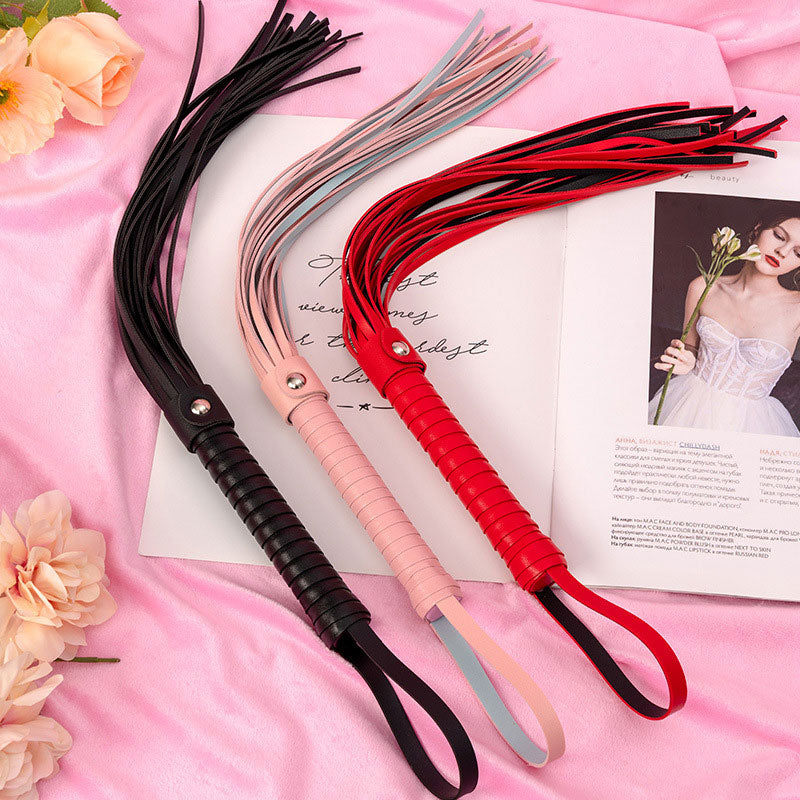 Wondebliss faux leather tassel whip in black, pink and red, three color options displayed together