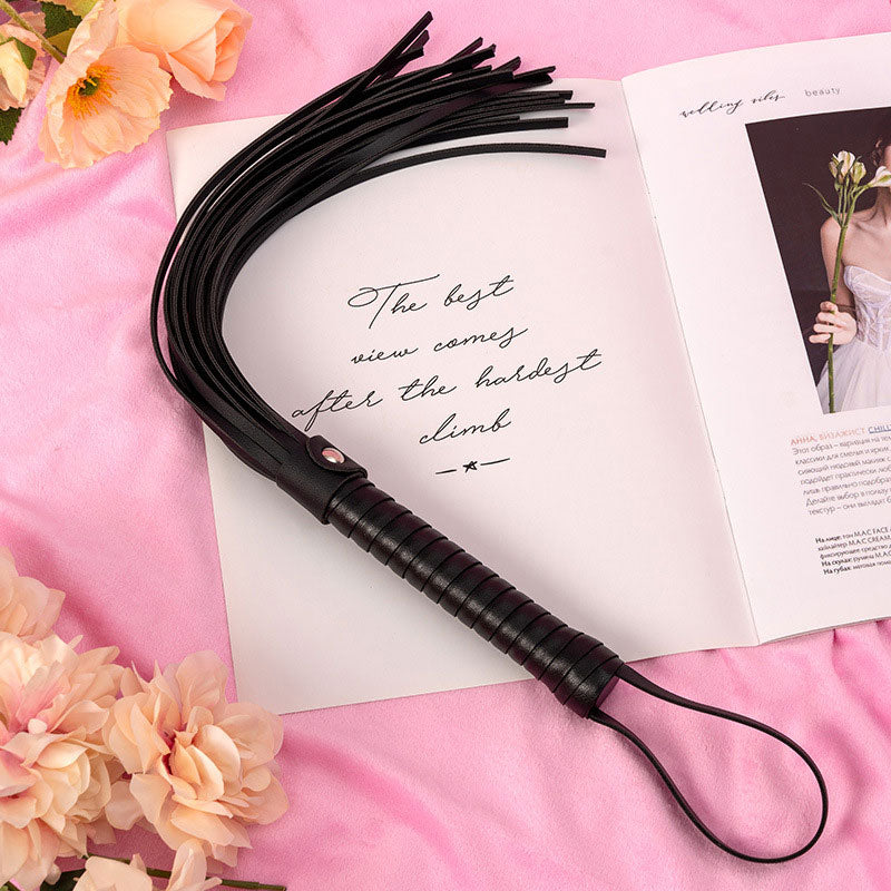 Wondebliss black faux leather tassel whip with metal hardware detail