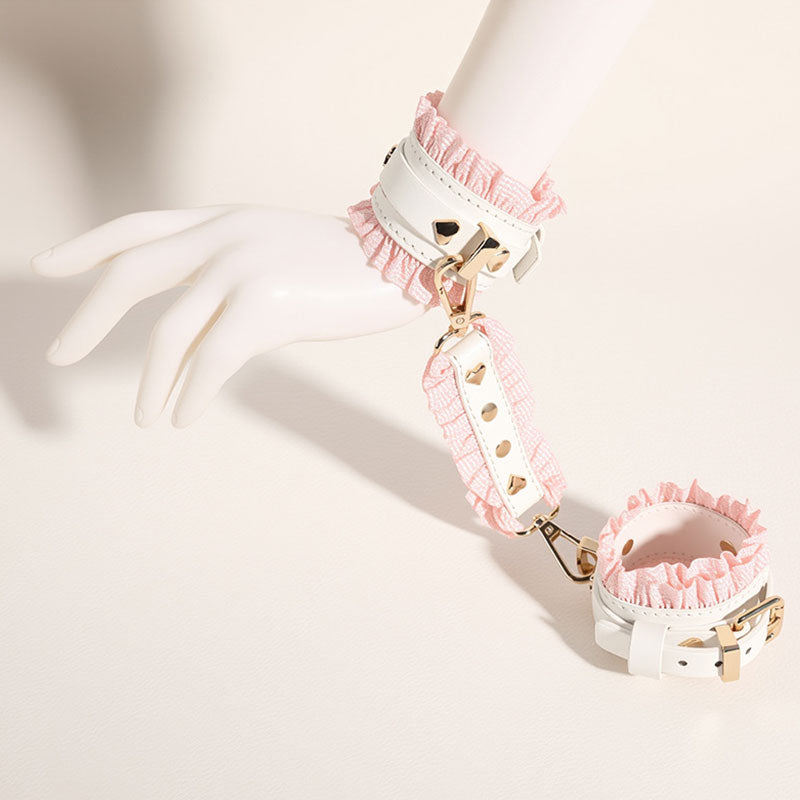 Wondebliss white and pink faux leather handcuffs with metal hardware from bondage set