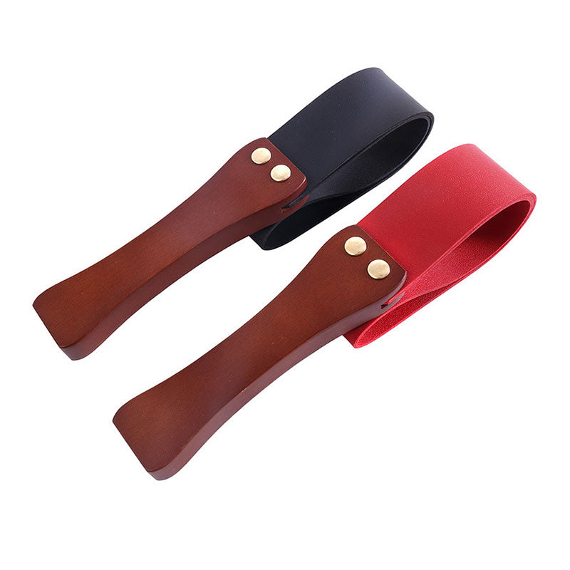 Wondebliss wooden handle spanking paddle in black and red showing elastic flexibility